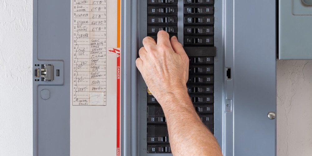 A man inspects an electrical Panel to insure good insurance coverage.